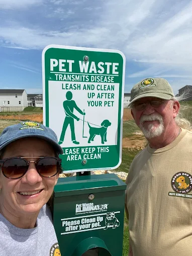 The founders of Doggie Doo Dude on-site at a pet waste station in a WV community