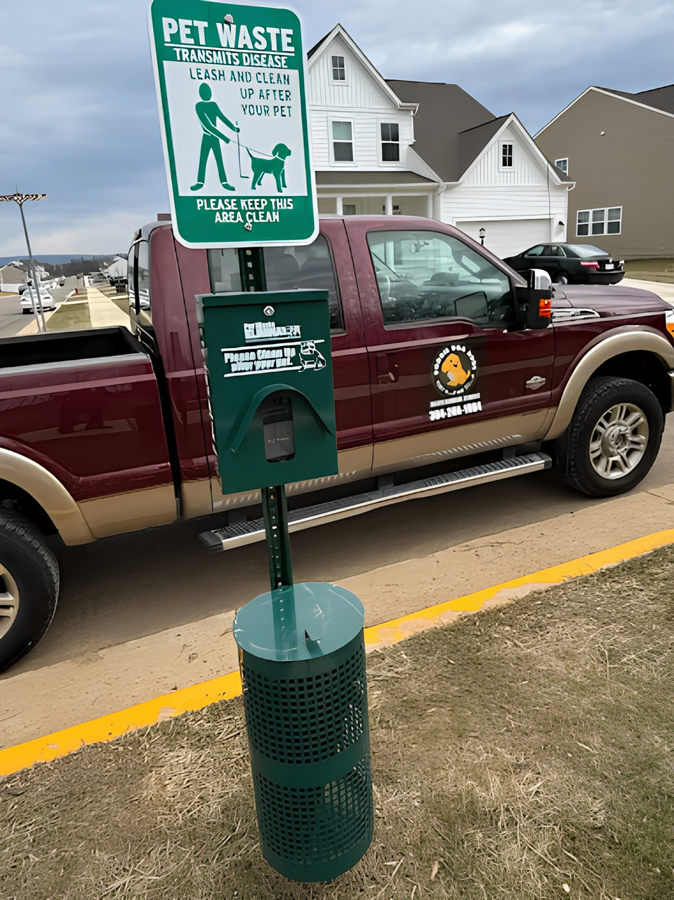Pet waste station and signage with Doggie Doo Dude branded truck in the background