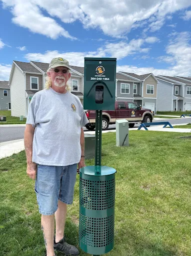 Doggie Doo Dude owner beside a freshly installed pet waste station